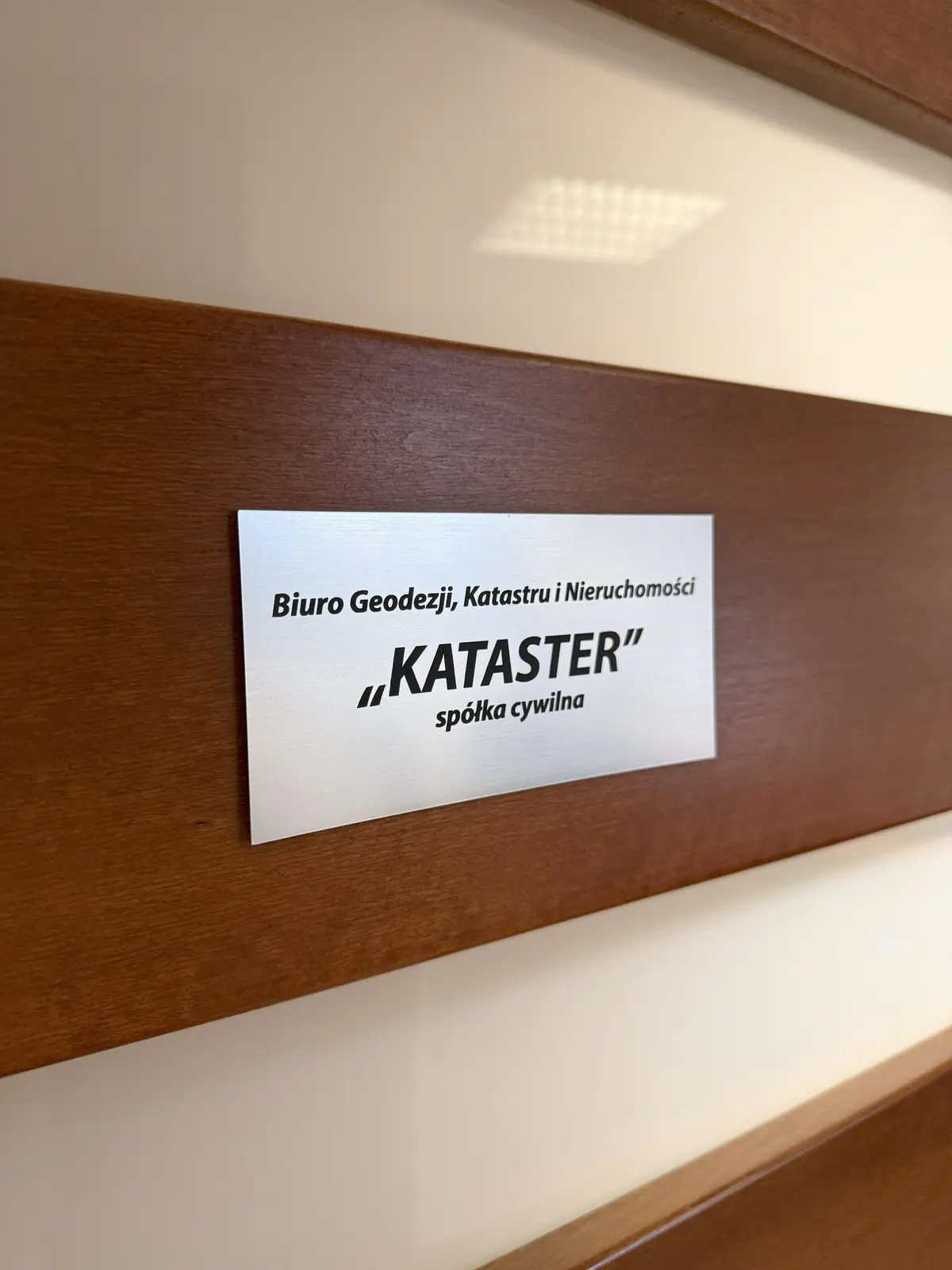 Tabliczka na drzwiach biura Kataster
